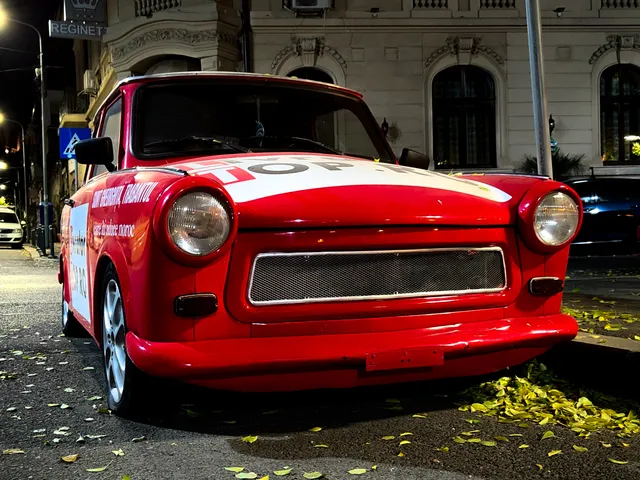 Trabant roșu colantat pentru campanie publicitară, fotografiat noaptea în București